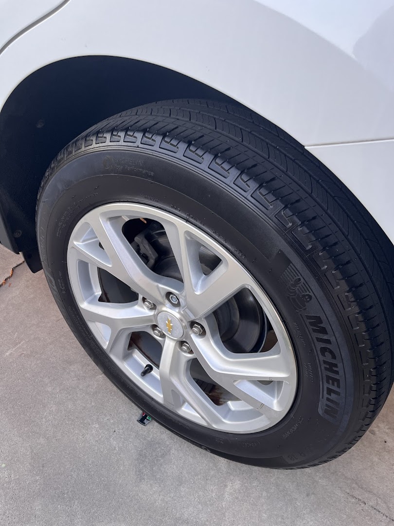 Clean Vibes wheel and tire detail — gleaming Michelin tire on white Chevrolet after exterior detail