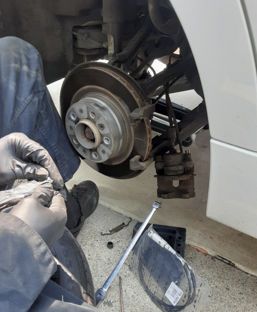 Close-up of wheel hub and suspension components during mobile mechanic work
